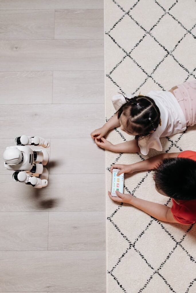 Two children interacting with a robot and smartphone on a carpet, showcasing modern technology playtime.